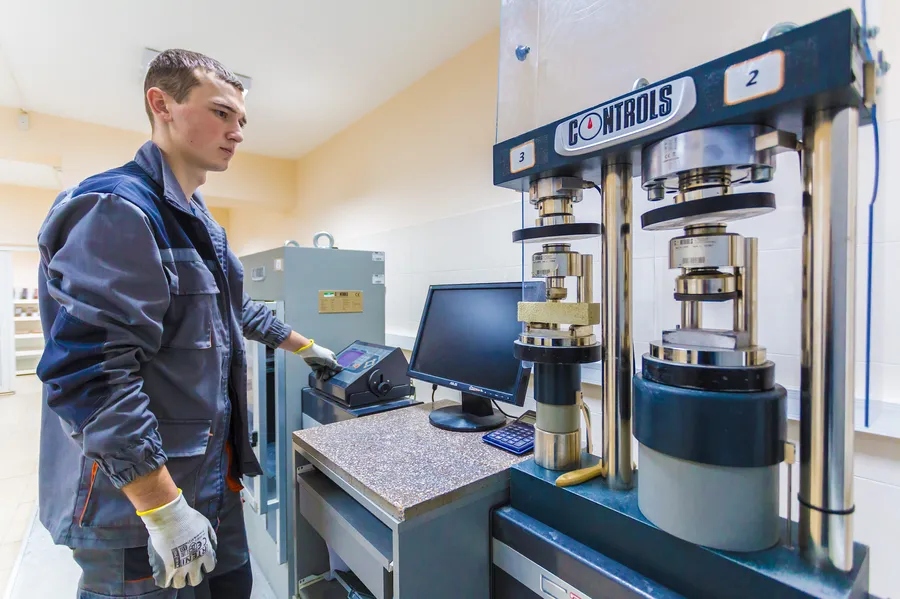 Technician operating compression testing machines in a laboratory